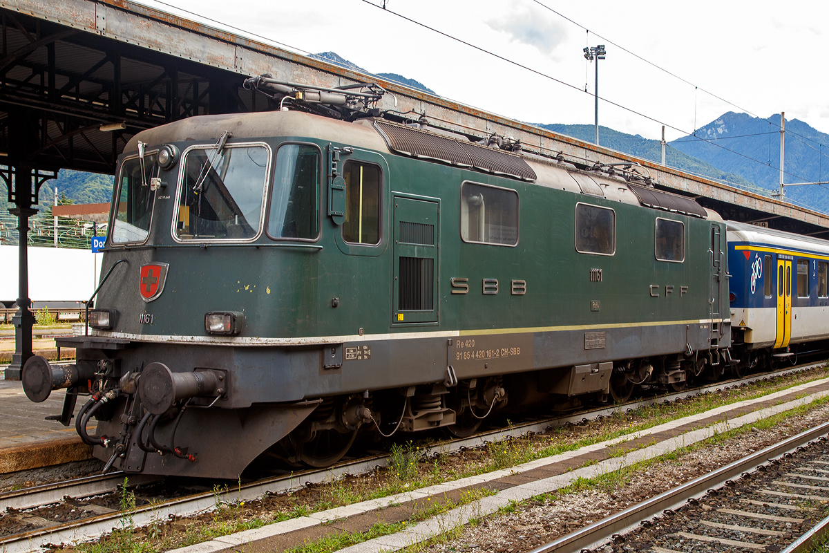 
Die grüne SBB Re 4/4 II – 11161 (2. Serie) bzw. SBB 420 161-2 (91 85 4 420 161-2 CH-SBB) mit einem Einheitswagen I-Pendel (EW I), Regionalzug nach Brig, am 15.09.2019 im Bahnhof Domodossola.

Die Re 4/4II ist eine vierachsige, viermotorige Lokomotive auf zwei Drehgestellen. Die Radsätze sind über Schraubenfedern am Drehgestellrahmen abgestützt. Das Drehgestell ist sekundär mit Schraubenfedern (ursprünglich Gummifedern) tief angehängt am Lokomotivkasten abgestützt. Die Zugkraftübertragung erfolgt über Tiefzugstangen von den Drehgestellen an den Lokomotivkasten.

Um einen besseren Kurveneinlauf des nachlaufenden Drehgestells zu ermöglichen, wurde zwischen den zwei Drehgestellen eine elastische Querkupplung eingebaut.

Diese Lokomotiven der zweiten Bauserie (11156–11349 und 11371–11397) haben zwei Einholmstromabnehmer und sind mit 15.410 mm (bei gleichem Drehgestellabstand) einen halben Meter länger als die Lokomotiven der 1. Serie. Die Stirnwände der Lokomotiven der 2. Serie sind etwas stärker geneigt als diejenigen der 1. Serie.

TECHNISCHE DATEN (2.Serie):
Spurweite:  1.435 mm (Normalspur)
Achsfolge:  Bo'Bo'
Hersteller: SLM / BBC / MFO / SAAS 
Dienstgewicht: 84 t (mit Klimaanlage)
Länge über Puffer: 15.410mm 
Drehzapfenabstand:  7.900 mm
Achsabstand im Drehgestell: 2.800 mm
Treibraddurchmesser:  1.235 mm
Breite:  2.970 mm
Höhe:  4.500 mm
Leistung: 4.700 kW (6.320 PS)
Stundenzugkraft: 167 kN
Anfahrzugkraft: 255 kN
Höchstgeschwindigkeit: 140 km/h
Stromsystem:  15 kV, 16,7 Hz AC
